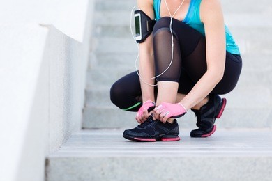 female runner trying running shoes and getting ready for run. healthy lifestyle concept.