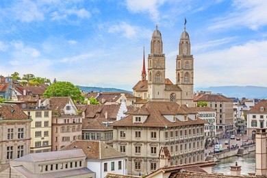 the grossmunster with town hall in front. it is a romanesque-style protestant church in zurich, switzerland. view from park lindenhof.