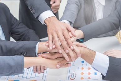 close up of group of people in suits crossed hands in pile for win closeup, cooperation initiative achievement, corporate life style, friendship deal, heap, stack concept