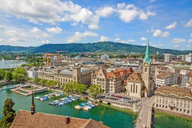 aerial view of historic zurich city center with famous fraumunster church, townhouse and river limmat at lake zurich from grossmunster church on a sunny day with clouds in summer, switzerland