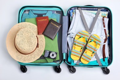 beach accessories in opened suitcase. travelling wheeled bag, different clothes.