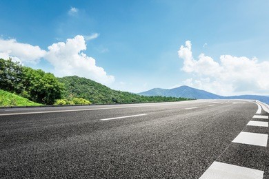 asphalt road and mountain under the blue sky
