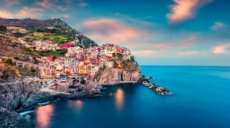 second city of the cique terre sequence of hill cities - manarola. colorful spring sunset in liguria, italy, europe. picturesque seascape of mediterranean sea. traveling concept background.