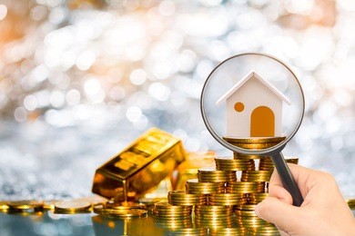 stacking coin growing and gold bar and a magnifier searching for a new home on the beautiful bokeh background, loans for real estate or save money for buy a new house to family in the future concept.