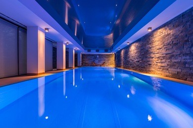 swimming pool with decorative led lights and brick wall