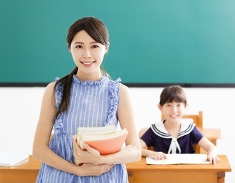 young teacher with little girl in classroom