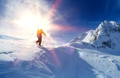 rear view of skier hiking to mountain summit
