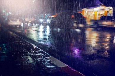 hard rain fall at night with blurry cars as background.selective focus.