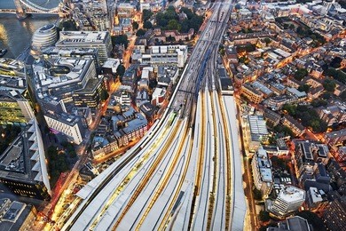 aerial view of train tracks entering london bridge illuminated at dusk 