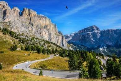 picturesque road through the sella pass, dolomites. the concept of extreme and ecological tourism. impressive ridge of dolomite rocks. "indian summer" in the tyrol