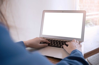 the casual business woman works online on laptop which hand on keyboard in her house isolated screen in laptop (blank white screen)