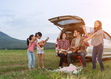 asian families are happy outside the car.