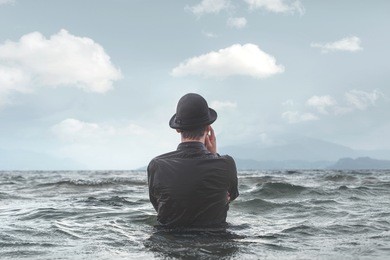 man thinking underwater observing clouds surreal concept
