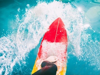 surfer on red surfboard ride on blue wave. surfing in ocean