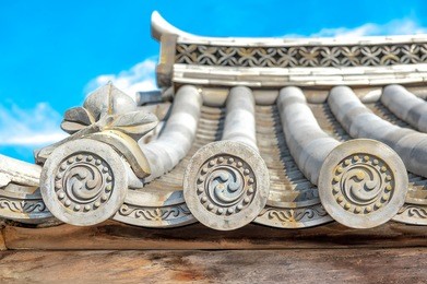 ornate design end pieces of roof tiles in traditional japanese and chinese architectures.