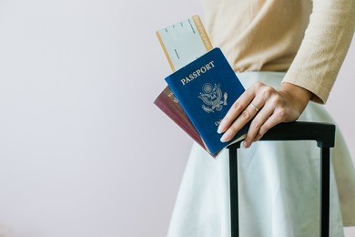 closeup of girl holding passports and boarding pass