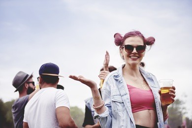 happy woman drinking a beer at festival 