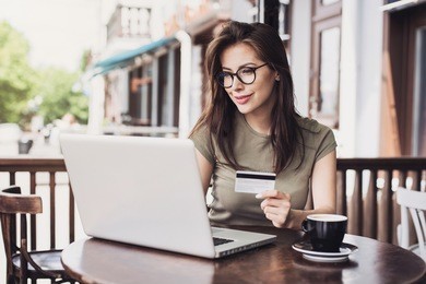 young woman holding credit card and using laptop computer. online shopping concept