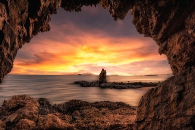the beautiful rock cave at the sea with sunrise sunset 