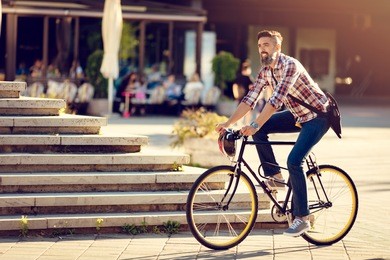 smiling casual businessman going to work by bicycle.