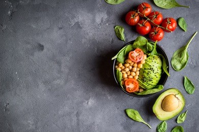 healthy vegetarian salad in bowl. background. salad with avocado, chickpeas, spinach, sesame. vegetarian concept. healthy diet/clean eating. space for text. buddha bowl. top view. making ingredients
