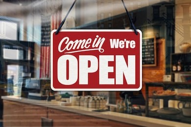 a business sign that says ‘come in we’re open’ on cafe/restaurant window.