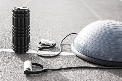 close up of a bosu ball on a running track. sport and fitness equipment. foam roller for massage and pilates ball.
