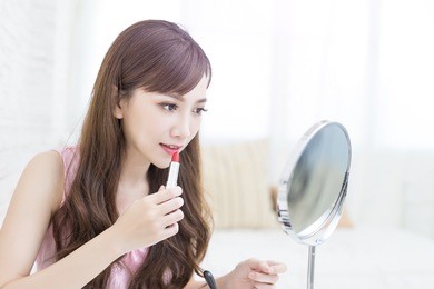 beauty woman use lipstick and look mirror in the room