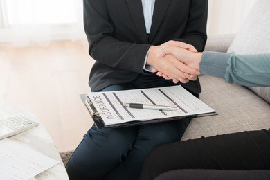 closeup photo of insurance agent lady planning best scheme for client and successful selling shaking hands with beneficiary.