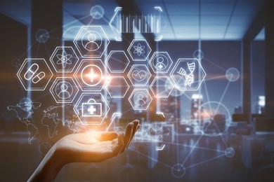 hand holding abstract glowing medical icons on blurry interior background. futuristic concept.  double exposure 