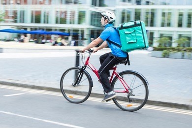 courier on bicycle delivering food in city