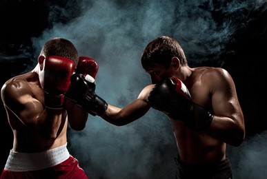 two professional boxer boxing on black smoky background,