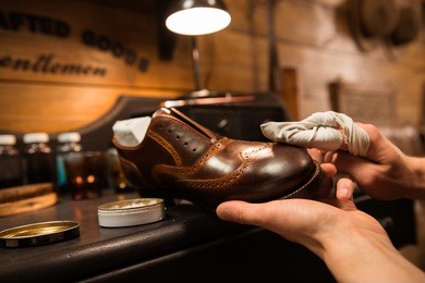 cropped image of young shoemaker in workshop making shoes.
