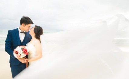 asian bride and groom kissing on the summer beach.bride and groom on a romantic moment on the sunset beach.
