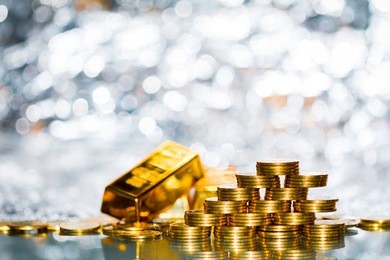 stacking gold coins with increase on the beautiful bokeh and gold bar background, saving money and loan for prepare in the future.