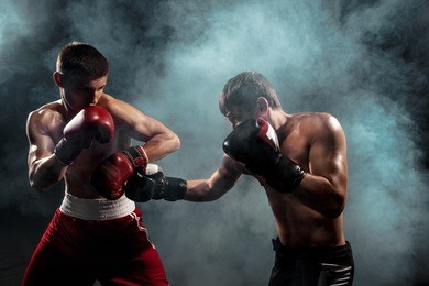 two professional boxer boxing on black smoky background,