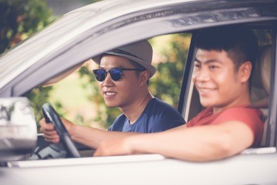 profile view of smiling vietnamese tourists having fun during long-awaited road trip