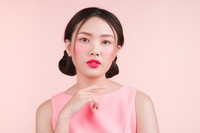 beautiful asian girl with professional makeup and stylish hairstyle  isolated on pink. cosmetics and make-up