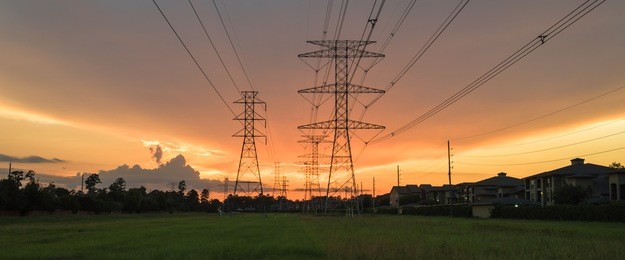 group silhouette of transmission towers (power tower, electricity pylon, steel lattice tower) at twilight in us. texture high voltage pillar, overhead power line, industrial background. panorama style