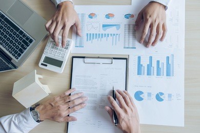 man sign a home insurance policy on home loans, agent holds loan investment chart graph documents and calculating table installment payment, real estate concept.