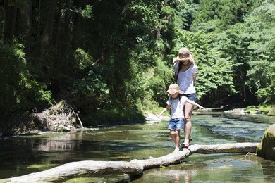 mother and daughter playing on mountain stream