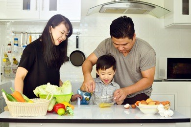 asian family cooking together in kitchen
