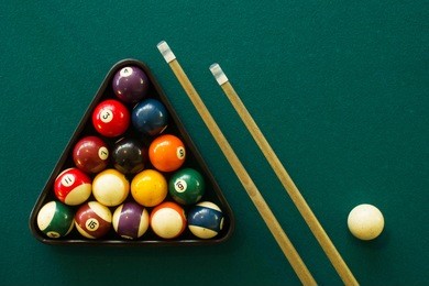 horizontal photo with negative space of a billiard table, balls and stick view from above