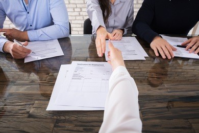 close-up of an applicant shaking hand with corporate recruitment officers in office