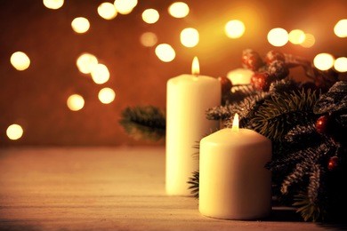 christmas candles and ornaments over dark background with lights