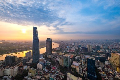dew and fog weather. colourful sunrise city with clouds on sai gon river and center in ho chi minh city (saigon).view from a roof of sai gon center building