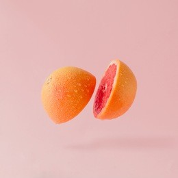 grapefruit sliced on pastel pink background. minimal fruit concept.