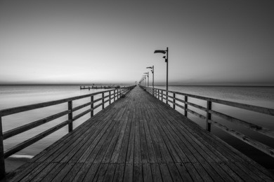 amazing sunrise on the pier at the seaside. mechelinki, poland. black and white photo