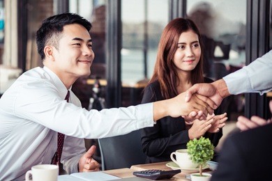 asian handshake with new partner in office room, success business concept.