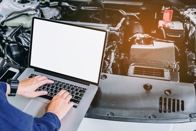 professional car mechanic working in auto repair service using laptop bon car